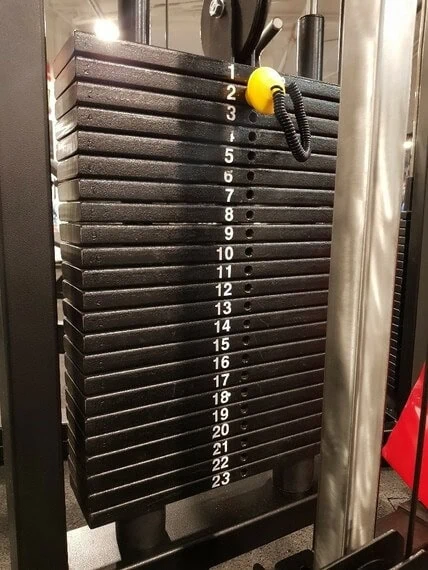 Painolevyt kuntosalilaitteessa, numerot näkyvissä.