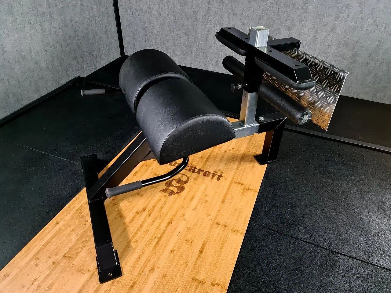 Kuntosalilaite mustalla istuimella.