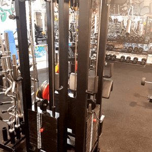 Moderni kuntosali, jossa musta kaksikaapelikone ja värikäs graffitiseinä taustalla