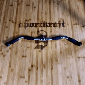 Sportkraft alumiininen polkupyörän ohjaustanko mustilla kumikahvoilla puisella taustalla