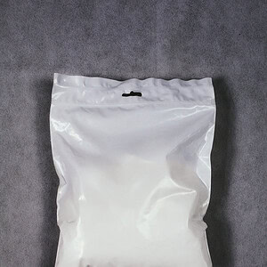 SportKraft jauhemagnesium urheiluun ja kiipeilyyn, valkoinen pussi harmaalla taustalla