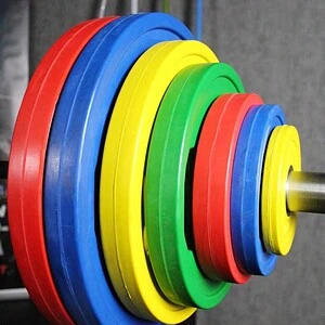 Värikäs SportKraft levypainosarja tangolla modernissa kuntosalissa