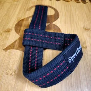 Tummansiniset SportKraft vetoremmit punaisilla tikkauksilla puupinnalla, vahvat ja laadukkaat voimaharjoitteluun.