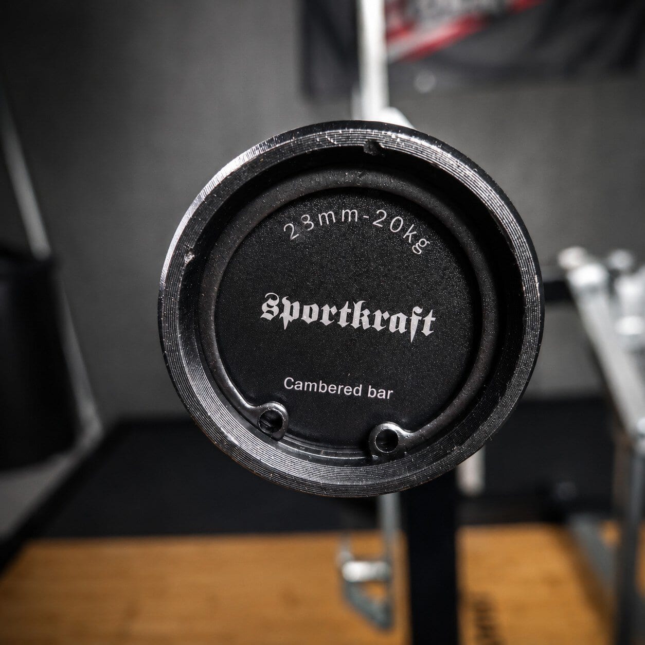 Lähikuva SportKraft Cambered bar -erikoistangon päädystä, jossa näkyy 28mm otepaksuus ja 20kg paino