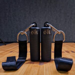 Mustat SportKraft otekahvat ja hihnat tehokkaaseen voimaharjoitteluun harmaalla taustalla.