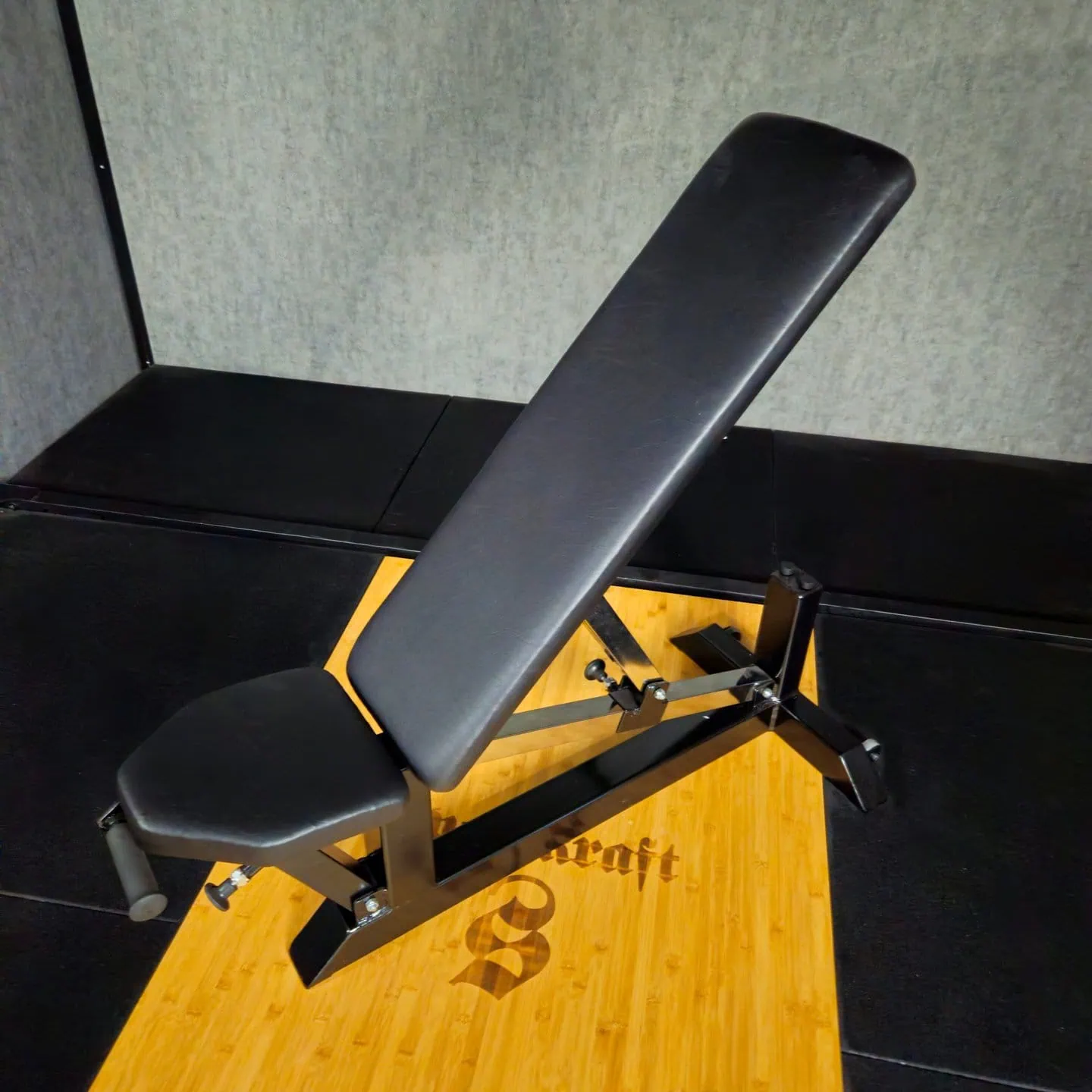 Säädettävä musta kuntopenkki metallirungolla ja bambualustalla kotikäyttöön ja voimaharjoitteluun.