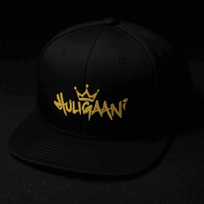 Musta lippalakki kultaatedalla tekstillä