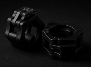 Kaksi mustaa metalliosaa, erikoismuotoiset kiinnikkeet.