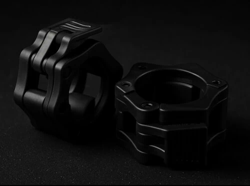 Kaksi mustaa metalliosaa, erikoismuotoiset kiinnikkeet.