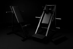 Kaksi mustaa kuntosalilaitetta pimeässä ympäristössä.