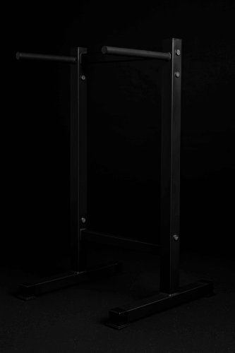 Modernit mustat rinnakkaistangot kehonpainotreeniin ja voimisteluun tummalla taustalla.